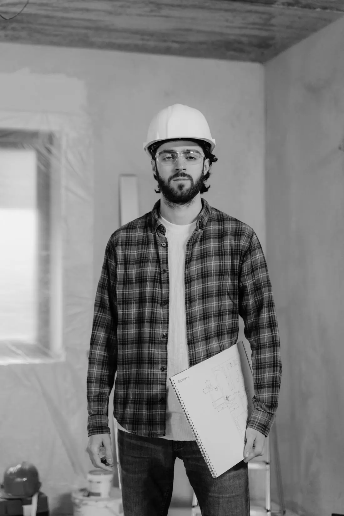 Engenheiro de capacete branco segurando um notebook em uma obra