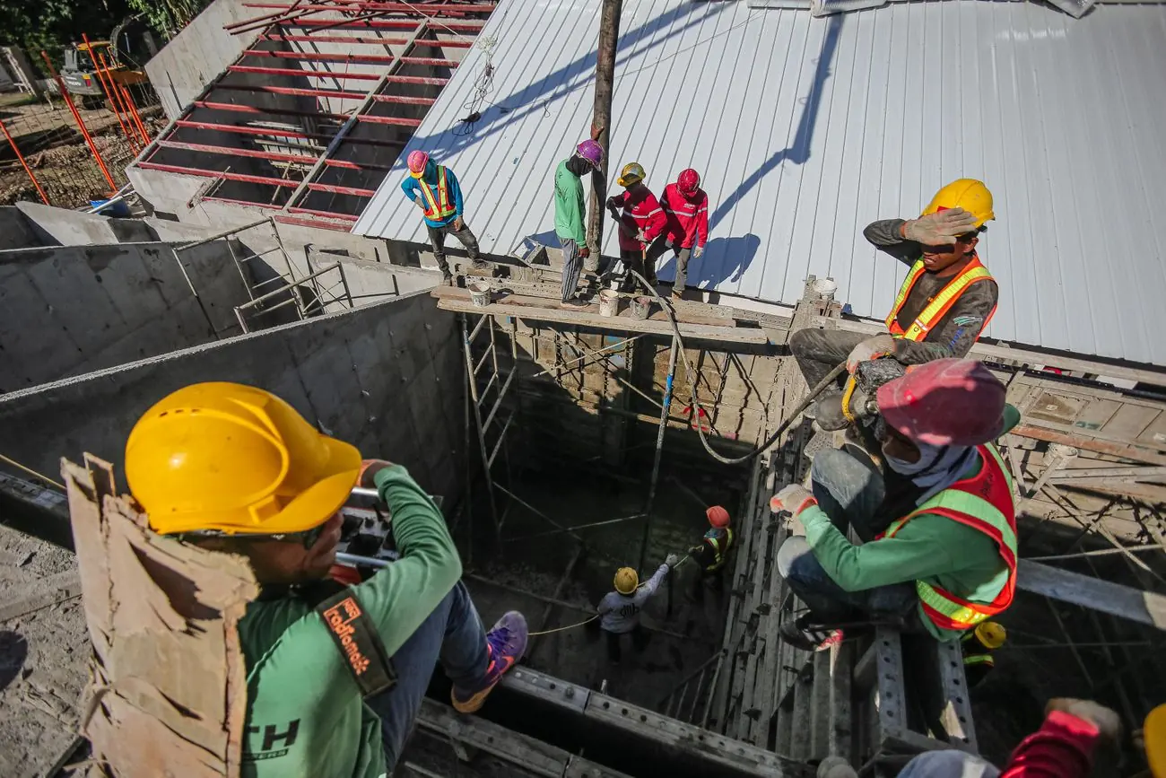 Equipe de capacete trabalhando na concretagem de uma fundação
